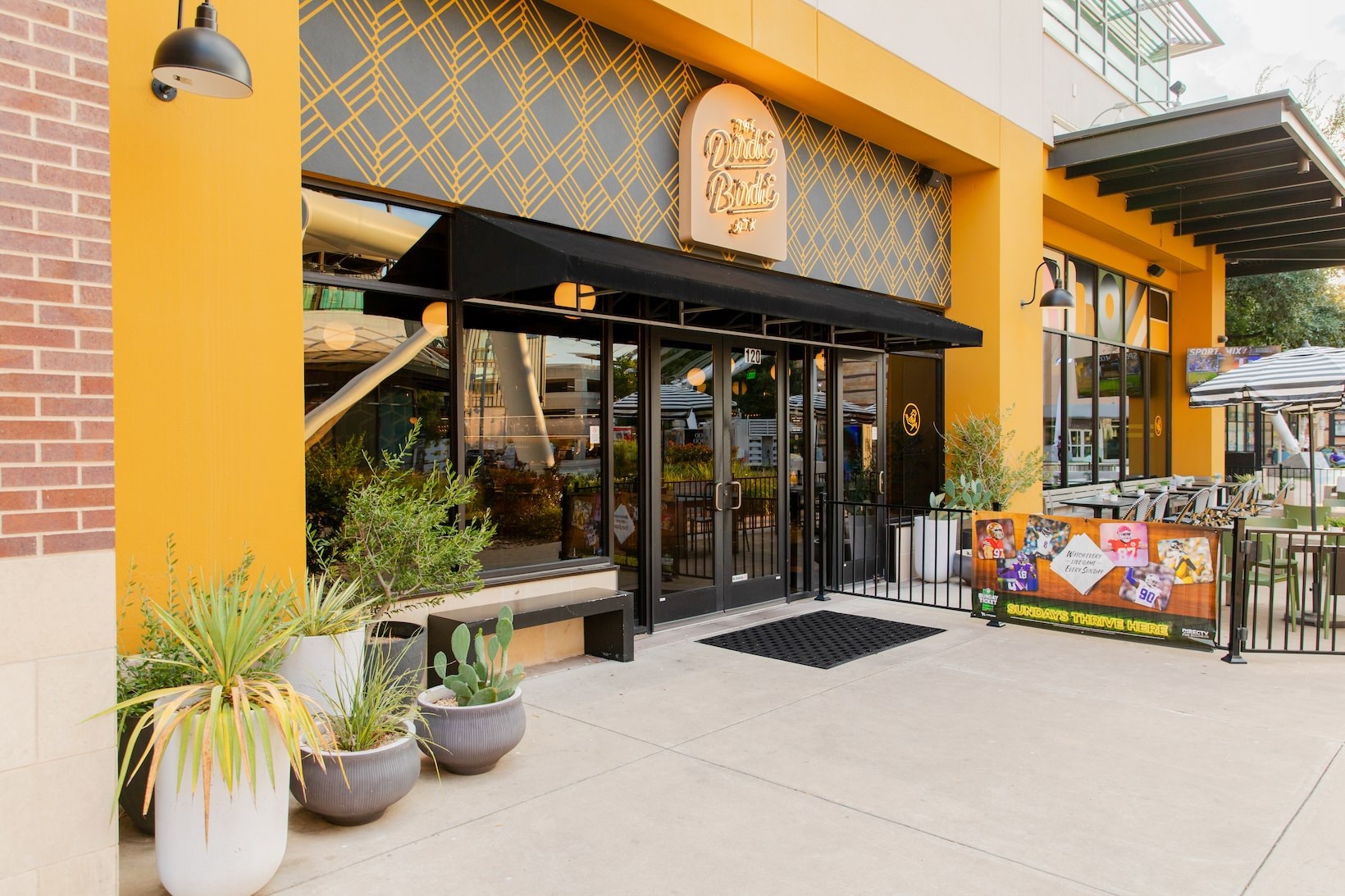 The Dirdie Birdie outdoor entrance with many windows and a sign